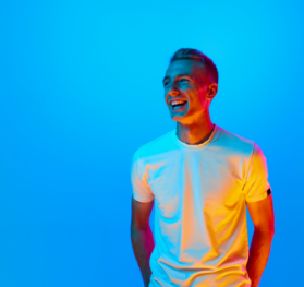 Person against bright blue background, smiling